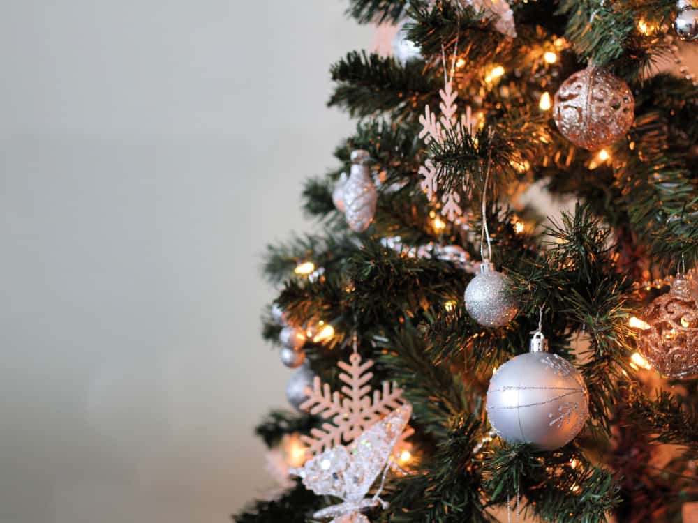 A Christmas Tree decorated with white and silver ornaments